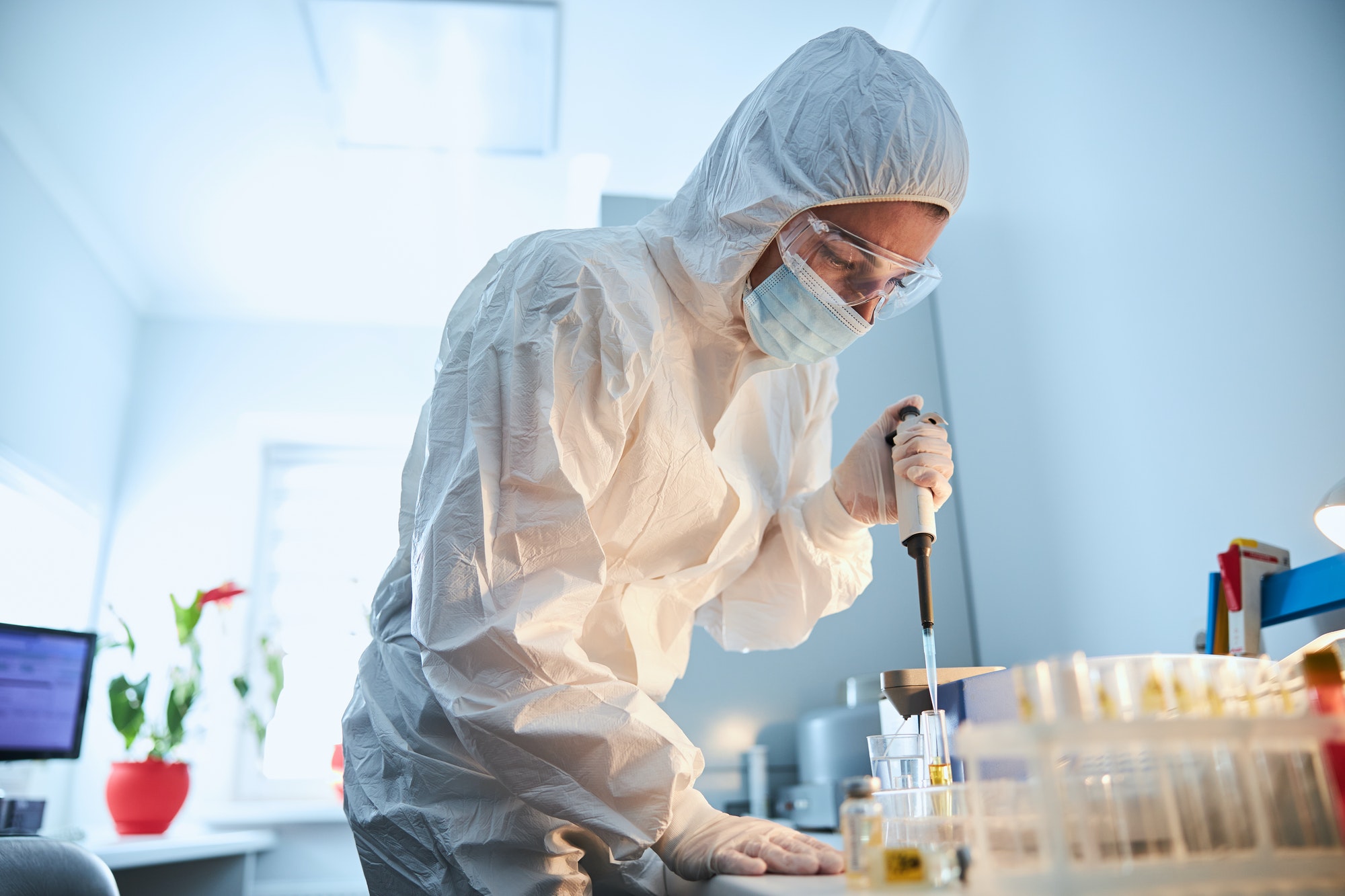 Scientist leaning over the serum sample in a test tube